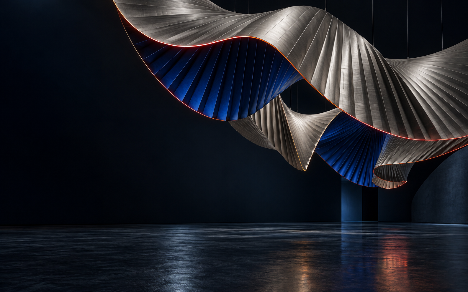 Sculptural red and blue folded forms in a dark architectural gallery